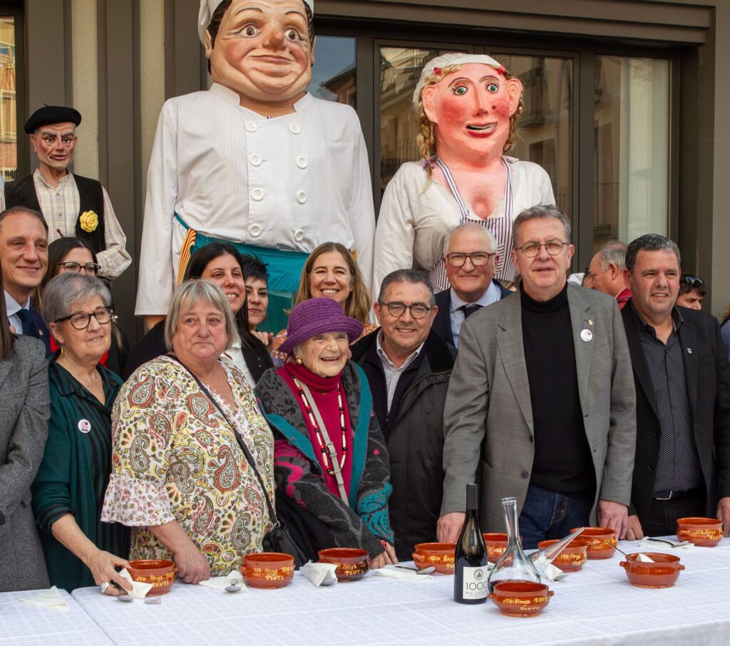 Grup d’autoritats i de convidats al tast de lo Ranxo amb els gegants Ranxet, Fal·lera i Mariano Claques darrere